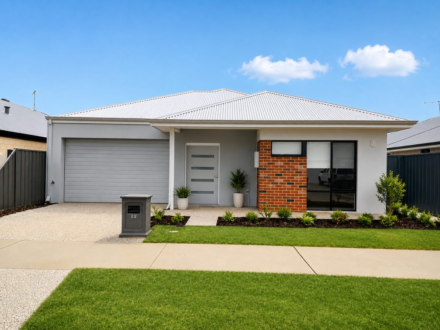 Front of a new single-storey home with a single garage, covered entry porch, paved driveway and landscaped front lawn