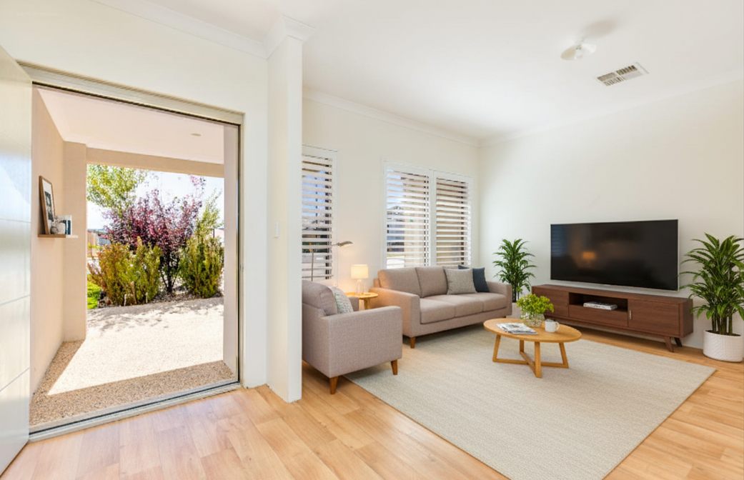 Bright living room with timber-look floors, plantation shutters and a wide opening to a covered front courtyard and garden